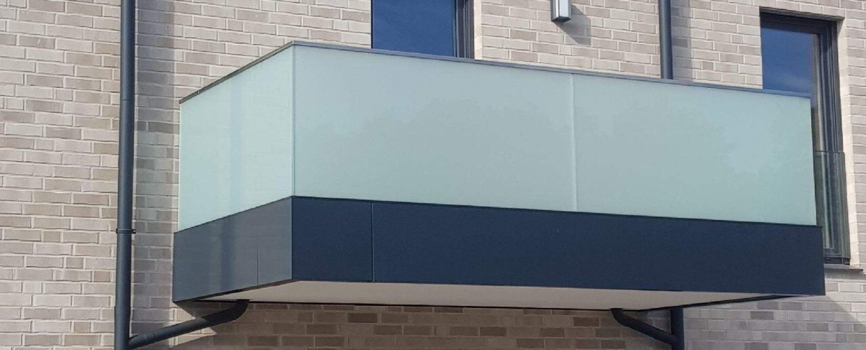 Die matte Glasbrüstung am Balkon ist eine edle Absturzsicherung aus Glas, hier in der Vorderansicht.