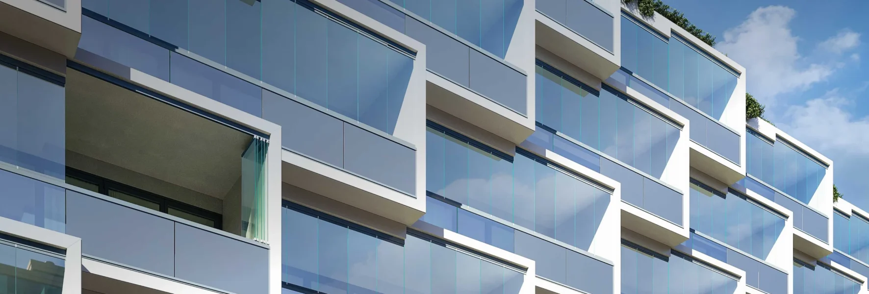 Großformatige Glas-Elemente ergeben eine puristische Ganzglas-Optik der Balkonfassaden dieses Mehrfamilienhauses.